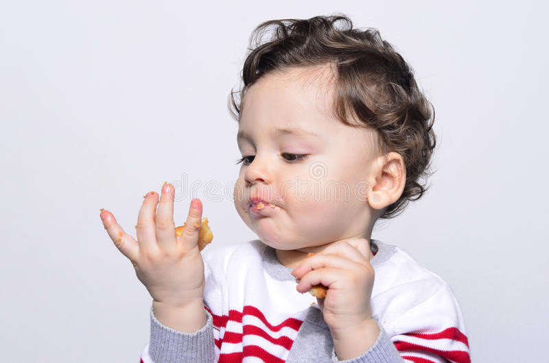 Baby Eating Hair
 Portrait A Cute Baby Eating A Biscuit Looking At The