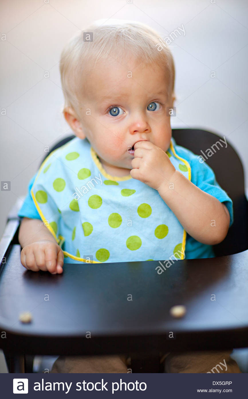 Baby Eating Hair
 Wide eyed baby boy eating cereal in high chair with polka