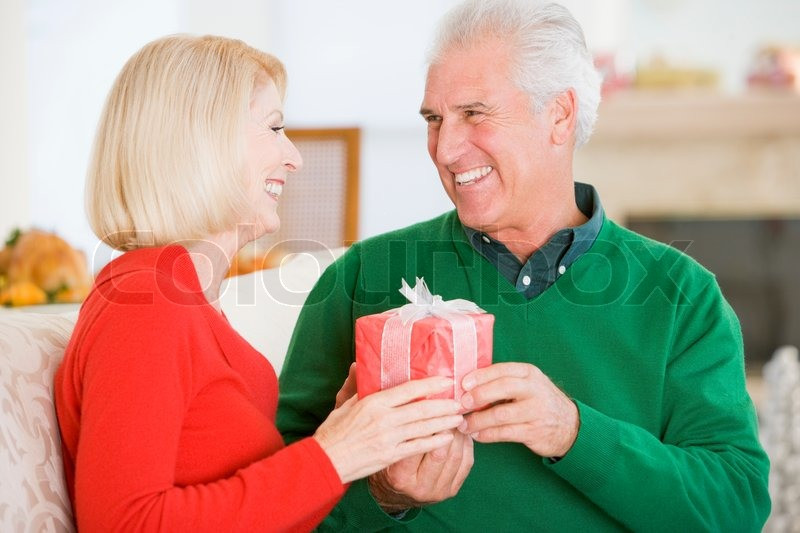 Christmas Gift Ideas For Older Couple
 An elderly couple in love exchanging ts on Christmas
