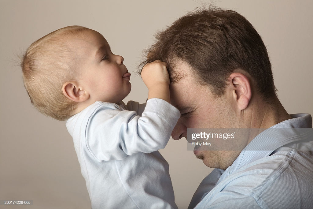 Baby Hair Pulling
 Baby Boy Pulling Fathers Hair Profile Foto de stock