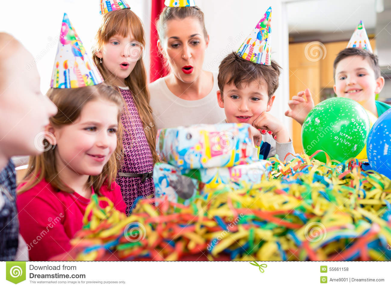 Children Birthday Gift
 Child Unwrapping Birthday Gift With Friends Stock