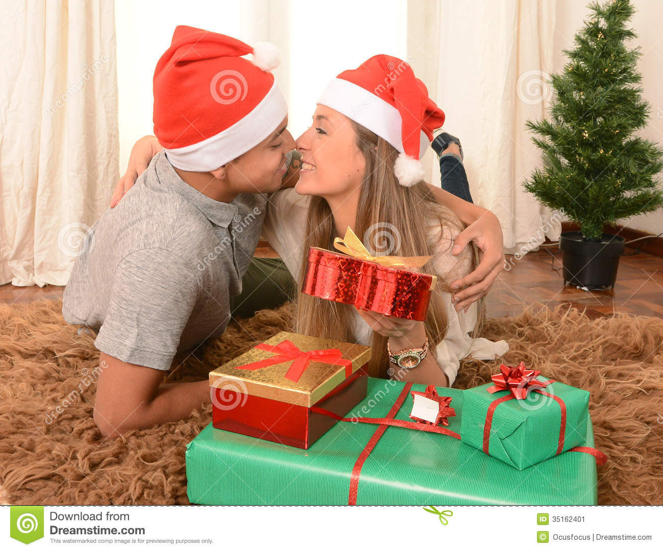 Christmas Gift Ideas For Young Couples
 Young Happy Couple Kissing Rug At Christmas Stock Image