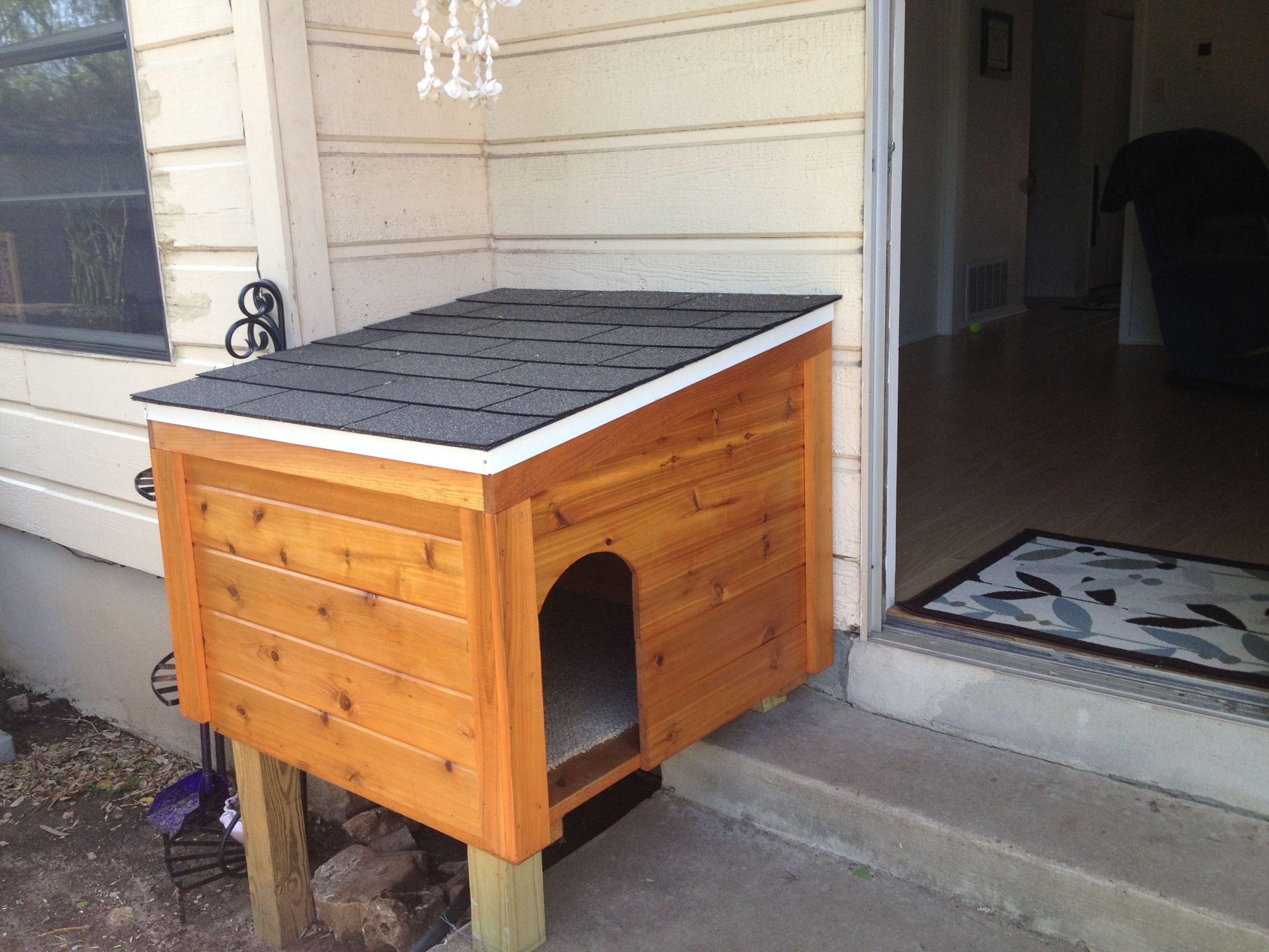 DIY Dog House Door
 Build a dog house in front of the doggy door to hide it