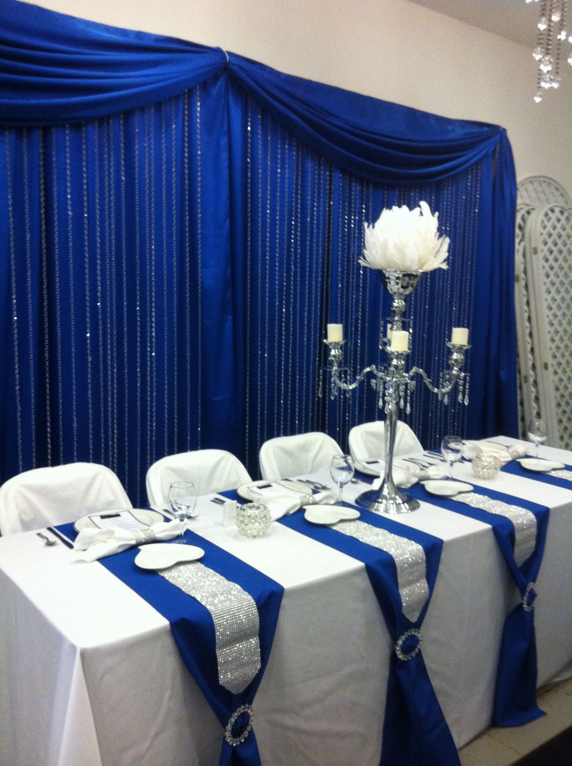 Royal Blue And Silver Wedding Decorations
 Head table with royal blue back drop and crystal step