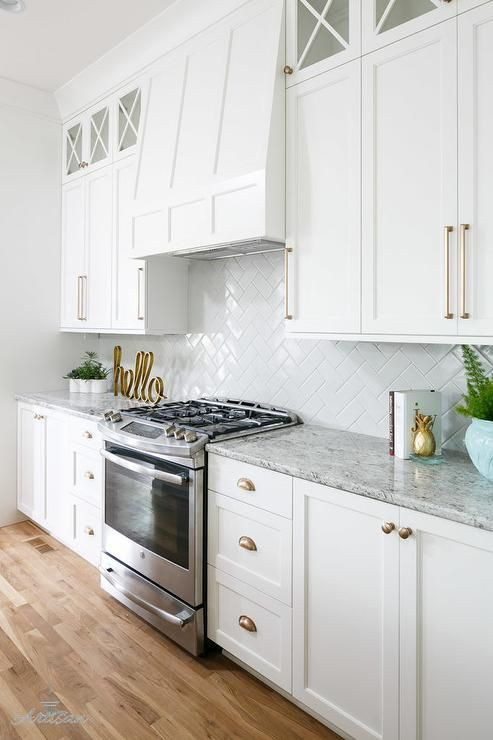 White Kitchen Cabinet Pulls
 A stainless steel oven range sits against white